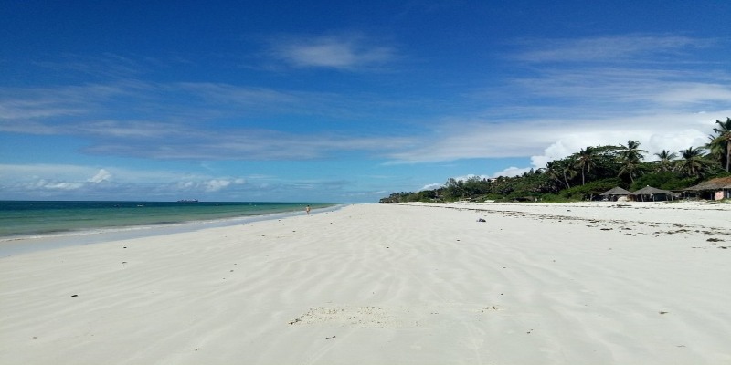 Beach shore at Cocoa Luxury Resort with white sand and clear blue ocean