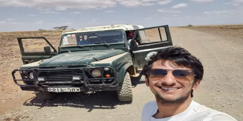 A traveler taking a selfie with a Land Rover Defender on a rugged road, a key part of the adventure in the Chalbi Desert Guide: Kenya’s Stunning White Salt Plain.
