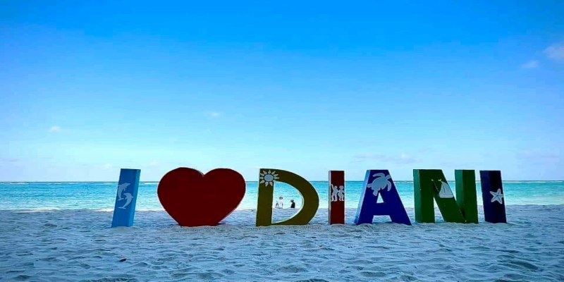 The colorful 'I Love Diani' sign on the white sands of Diani Beach, Kenya, with the turquoise Indian Ocean in the background