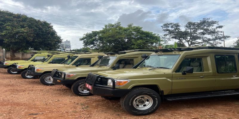 A fleet of olive-green Toyota Land Cruiser safari vehicles lined up for a private tour, showing uniform maintenance and specialized roof racks for Kenyan safaris